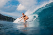 Surf girl at surfboard ride on barrel wave. Woman in ocean during surfing