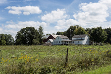 Plain White Farmhouse With Overgrown Grass