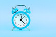 © breakingthewalls - Close up one blue alarm clock over pastel background