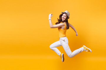 Portrait of excited smiling young happy jumping high woman in straw summer hat, copy space isolated on yellow orange background. People sincere emotions, passion lifestyle concept. Advertising area.