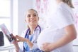 © lenets_tan - Smiling woman doctor shows pictures on the tablet to pregnant young woman at hospital.