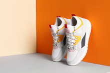 Pair Of Stylish Sneakers Near Color Wall, Space For Text