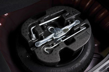 Car Jack And Wheel Changing Tool Kit In Spare Tyre Of Car, Automotive Part Concept.