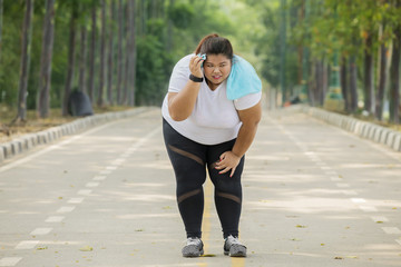 Obese woman looks tired after running