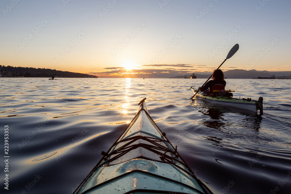 Girl Sea Kayaking during a vibrant sunny summer sunset. Taken in Vancouver, BC, Canada. - obrazy, fototapety, plakaty 