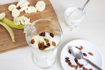 Canvas Print - How to make sweet banana layer dessert with yogurt and raisins