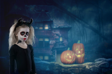 Halloween, holidays, masquerade concept - the portrait of young little beautiful girl with skull makeup and horns. Halloween, face-art, skull make up concept.