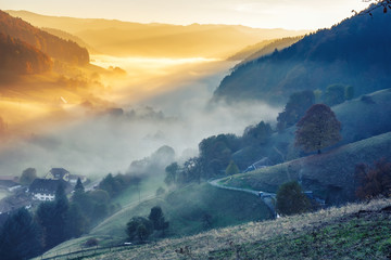 Scenic foggy mountain landscape with an old monastery in Black Forest, Germany. Colorful travel background.