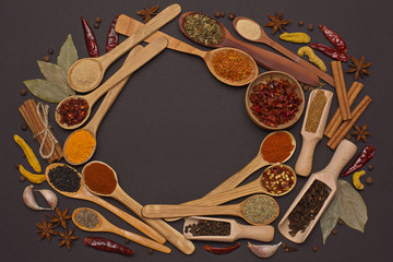 Spice. Seasoning in a wooden spoon. Herbs. Curry, saffron, turmeric, pepper and others on a gray background.