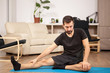 © DC Studio - Young man practicing yoga in his living room at home. He is strecking and feels relaxed