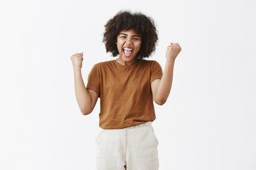 Wall Mural - yes we did it team. portrait of cheering carefree and happy triumphing african american teenage girl