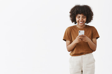 Wall Mural - studio shot of entertained cute happy african american teenage girl with afro hairstyle in brown t-s