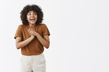 Wall Mural - studio shot of excited and dreamy good-looking fit african american female with afro hairstyle laugh