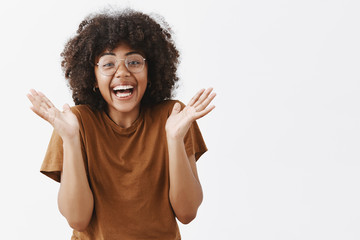 Wall Mural - waist-up shot of surprised playful and touched good-looking african american woman in glasses and st