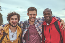 Diverse But Together. Waist Up Portrait Of Positive Guys Making Friendly Embrace And Smiling In Front Of Camera