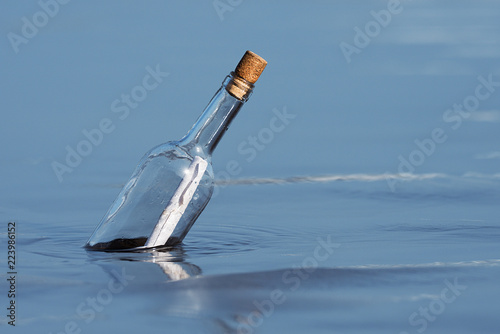 Fotografía Message in a bottle floating on sea level