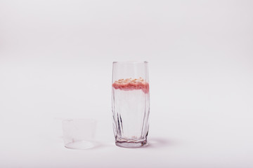 Wall Mural - Undissolved pink whey protein in glass of water