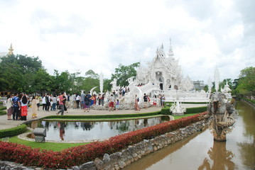 Entrance into Wat Rong Khun alias the White Temple of Chiang Rai in Thailand with long queue of tourists