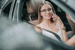 © Yakobchuk Olena - Portrait of beaming young businesswoman telling on cellphone while relaxing on comfortable seat of vehicle. She looking at camera. Glad lady communicating on appliance concept