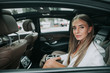 © Yakobchuk Olena - Portrait of calm businesswoman looking at window from rear seat of comfortable contemporary automobile with sunroof