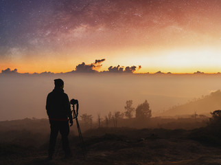Wall Mural - traveller taking photograph of landscape sunrise and sky full of stars in dawn