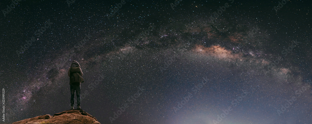 Night sky full of star and milky way, with traveller with backpack enjoying beautiful sky at night - obrazy, fototapety, plakaty 
