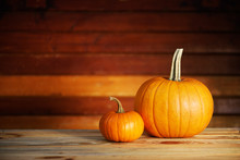 Two Pumpkins On Wooden Table. Halloween And Autumn Food Background