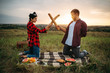 © Nomad_Soul - Playful couple fight on loaves, picnic in field