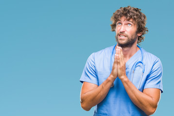 Sticker - Handsome hispanic surgeon doctor man over isolated background begging and praying with hands together with hope expression on face very emotional and worried. Asking for forgiveness. Religion concept.