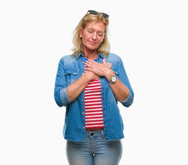 Sticker - Middle age blonde woman over isolated background smiling with hands on chest with closed eyes and grateful gesture on face. Health concept.