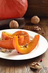 Wall Mural - Slices of pumpkin baked in the oven with walnuts and spices, vertical