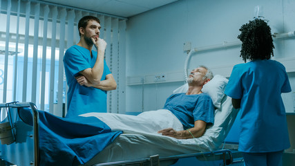 Wall Mural - Modern Medical Ward with Sick Patient Lying in Bed and Doctor Thinking About His Treatment. Nurse Does Checkup. Technology Helps Cure Patients.