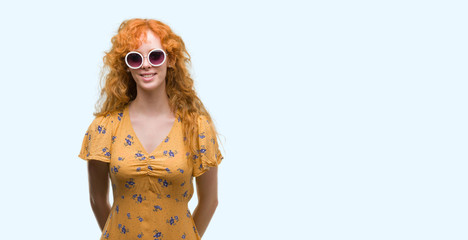 Sticker - Young redhead woman wearing sumer outfit and sunglasses with a happy face standing and smiling with a confident smile showing teeth