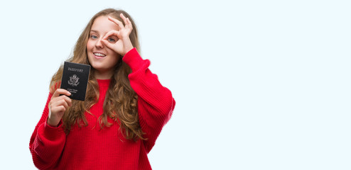 Wall Mural - Young blonde woman holding passport of United States of America with happy face smiling doing ok sign with hand on eye looking through fingers