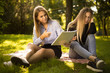 © Sunrise Team - Displeased young beautiful ladies students sitting in the park outdoors on grass holding copybook doing homework.