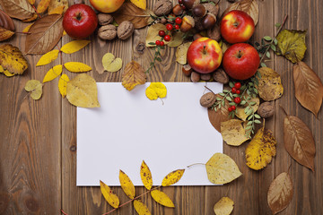 autumn background, empty card and autumn leaves on wooden background