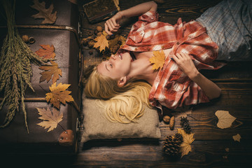 Wall Mural - Girl in autumn in a seasonal clothes whith golden leaf. Autumn concept. Beautiful girl on wood background board for Copyspace. Having fun.