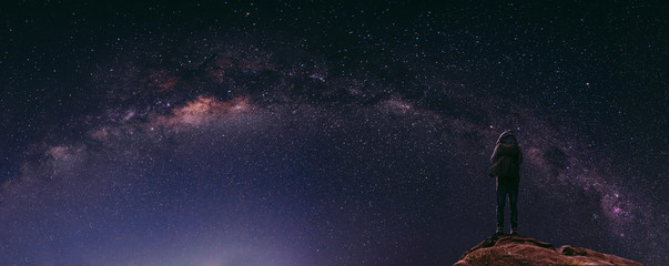 Wall Mural - night sky full of star and milky way, with traveller with backpack enjoying beautiful sky at night