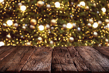 Wall Mural - christmas and new year background with empty wooden deck table over blurred christmas tree at night.
