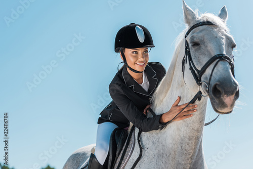 Cuadros en Lienzo attractive female equestrian riding beautiful white horse at horse club