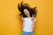 Leinwandbild Motiv Image of european woman 20s laughing and having fun with shaking hair, isolated over yellow background
