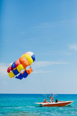 Wall Mural - Couple of tourists flying on a colorful parachute