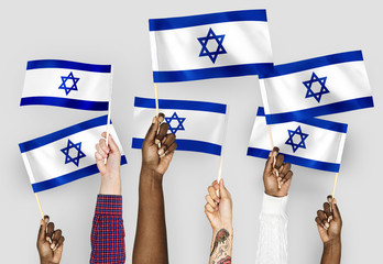 Wall Mural - Hands waving flags of Israel