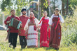 © KONSTANTIN SHISHKIN - Group of men and women in russian folk costumes in nature. Celebration