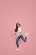 © master1305 - Freedom in moving. Mid-air shot of pretty frightened running away young woman jumping against pink studio background. Runnin girl in motion or movement. Human emotions and facial expressions concept