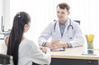 © Suthiporn - Medical professionals caucasian man reassuring and talking with young woman stress patient.Close up and copy space.