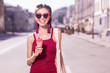 © Viacheslav Yakobchuk - Summer dessert. Joyful positive woman eating ice cream while having a walk around the city