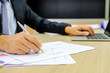 © subinpumsom - Businessman using red pen writing in notepad on office table