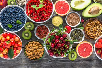 Wall Mural - Healthy food selection. Super foods on table. Breakfast in a bowls with fruits, fresh berries, organic seeds and nuts. Vegan diet concept.