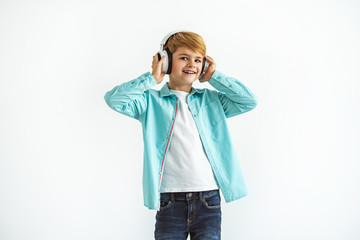 Wall Mural - The boy in a headphones standing on the white background